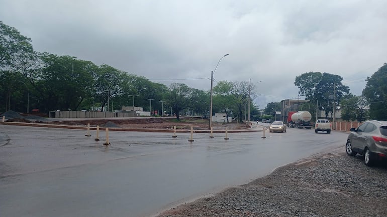 Intersección vial en Coronel Oviedo con vehículos en movimiento y trabajos de construcción bajo un cielo nublado.