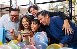Un grupo de compañeros de trabajo celebra un cumpleaños en la oficina.