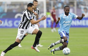 El extremo paraguayo del Santos, Gustavo Caballero, y el mediocampista del Macará, Jean Carlos Estacio, luchan por el balón durante el partido de vuelta de los octavos de final de la Copa Sudamericana disputado en el estadio Bellavista en Ambato, Ecuador.