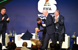 Lionel Scaloni acomoda la Copa del Mundo sin utilizar los guantes, que se los puso posteriormente.