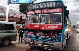 Autobús de transporte público dañado y agente de seguridad en uniforme negro coordinando situaciones tras el accidente.