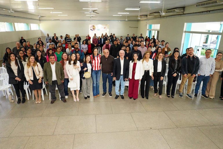 Basilio Núñez y Luis López rodeados de personas en el salón de la Municipalidad de Villa Hayes.