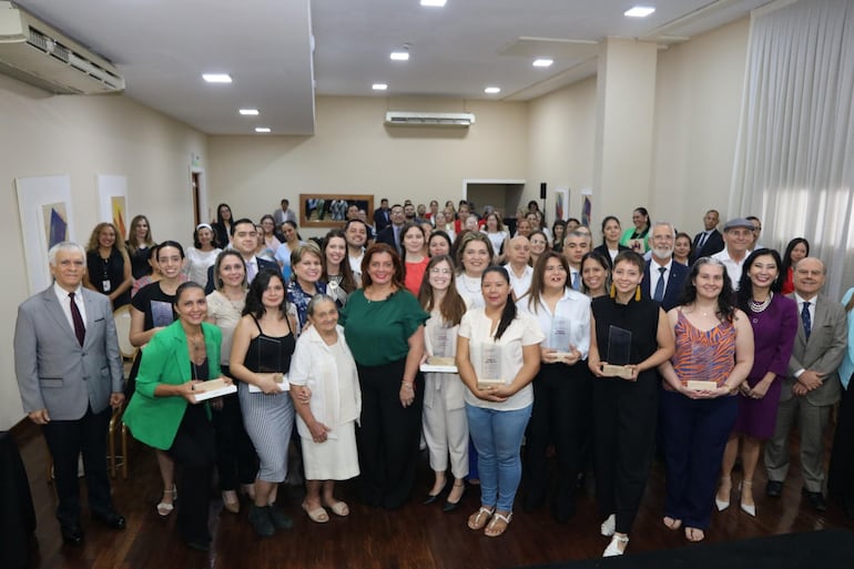 Las ganadoras del concurso fotográfico "Mujeres que hacen" rodeadas de los presentes entre los que se encontraban diplomáticos, autoridades e invitados especiales.