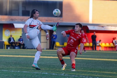 Diego Máximo "Chino" Martínez (izquierda), goleador del Atlético Tembetary, levanta la pierna intentando conectar el balón ante el marcador de punta Alfredo Duarte.