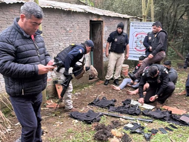 El director general de Investigación Criminal, Marcelino Espinoza (con celular en mano), junto a las evidencias incautadas hoy en el aguantadero de Minga Guazú.