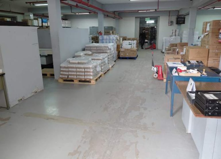 Almacén interior con estantes y paletas de cajas de medicamentos sin personas visibles.