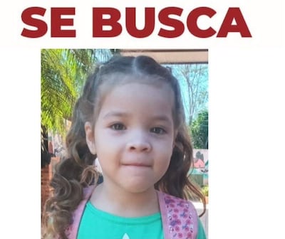 Niña de 5 años con cabello rizado y camiseta verde, en un entorno exterior con texto 'SE BUSCA' en rojo.