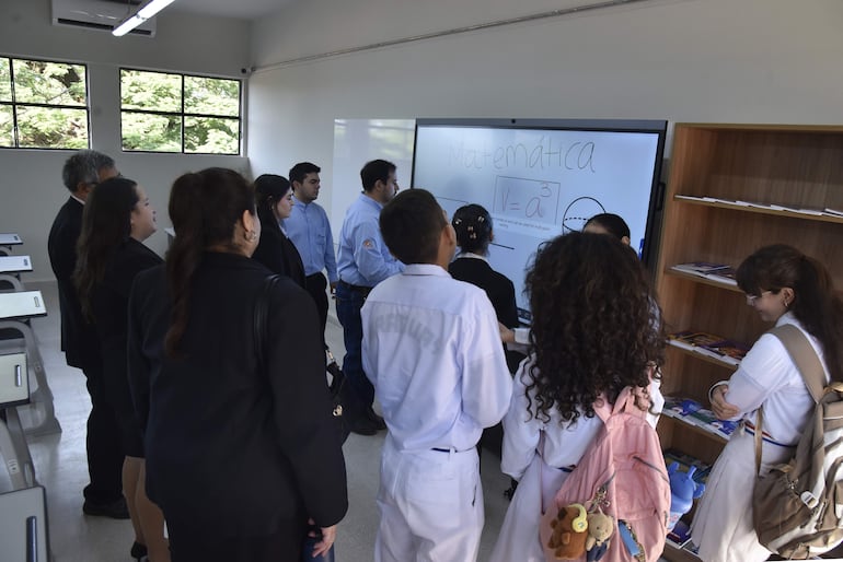 Estudiantes y docentes observan una de las pizarras inteligentes instaladas en el CNC.