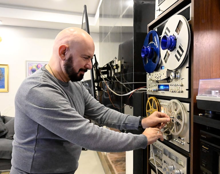 Jorge Puig manipula un equipo de audio analógico en su colección en Lambaré.