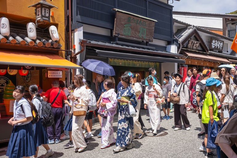 Kioto, Japón. Mujeres en kimono mientras visitan Kiyomizu Zaka, una calle comercial llena de tiendas, salones de té y restaurantes que sirven cocina y recuerdos locales al estilo de Kioto.