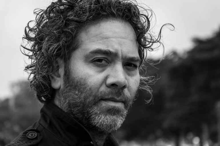 Retrato de un hombre con barba y rostro tranquilo, en un ambiente cultural reflejando la conexión entre literatura y música.