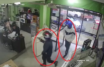 Captura de video de circuito cerrado donde se observa a dos hombres armados ingresando al lugar.