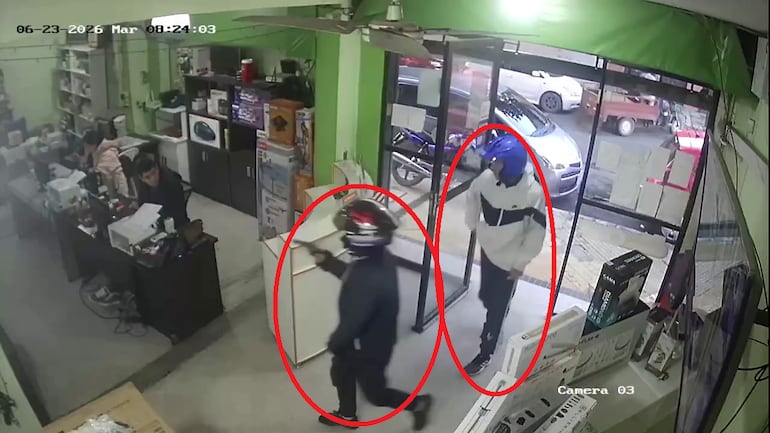 Captura de video de circuito cerrado donde se observa a dos hombres armados ingresando al lugar.