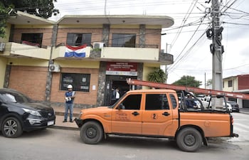 Funcionario en casco blanco y uniforme azul supervisa desconexión del medidor, mientras una camioneta naranja está estacionada cerca.