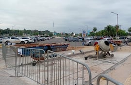 Área de construcción en el aeropuerto con mezcladora de cemento y barreras de seguridad, bajo un cielo nublado.