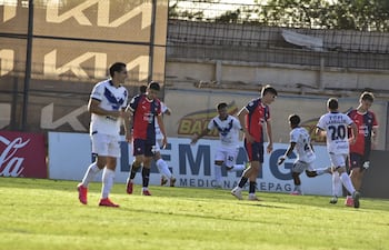 Los jugadores de Cerro Porteño se lamentan tras el tanto de Raúl Cabral, quien celebra de fondo la anotación que le dio el triunfo al Sportivo Ameliano en Villeta.