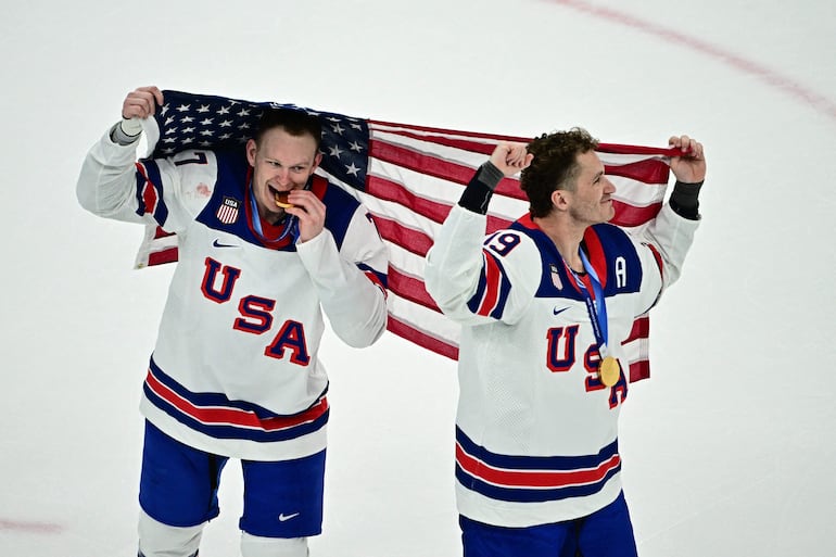 Brady Tkachuk  y  Matthew Tkachuk celebran durante la ceremonia de entrega de medallas del evento   de hockey.