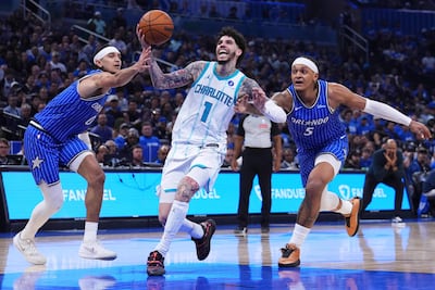LaMelo Ball, del Charlotte Hornets maniobra ante Anthony Black, del Orlando Magic, que ganó por amplia diferencia.