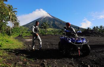 El personal de la Guardia Costera de Filipinas (PCG) hace guardia mientras el volcán Mayon arroja cenizas y lava en la ciudad de Daraga, provincia de Albay, Filipinas, el 18 de junio de 2023.