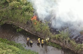 Bomberos voluntarios intentan apagar las llamas de un foco de calor. Gentileza Infona.