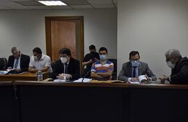 El abogado Jorge Darío Cristaldo (primero de la derecha), el suboficial Jorge Mendoza (de remera a rayas) y el Crio. Hugo Ayala (de camisa blanca) escuchan el fallo del Tribunal de Sentencia, en el primer juicio de 2021.