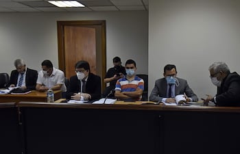 El abogado Jorge Darío Cristaldo (primero de la derecha), el suboficial Jorge Mendoza (de remera a rayas) y el Crio. Hugo Ayala (de camisa blanca) escuchan el fallo del Tribunal de Sentencia, en el primer juicio de 2021.