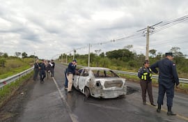 Efectivos de la policía nacional realizando la verificación del lugar donde los malvivientes incendiaron uno de los vehículos utilizado en el atraco