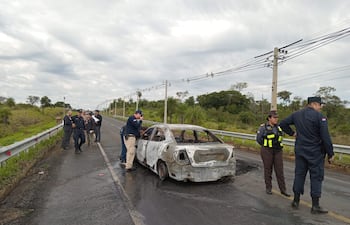Efectivos de la policía nacional realizando la verificación del lugar donde los malvivientes incendiaron uno de los vehículos utilizado en el atraco
