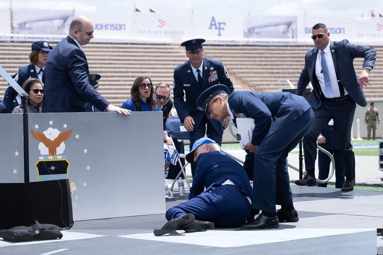 El presidente Joe Biden siendo ayudado tras la caída en pleno acto público.