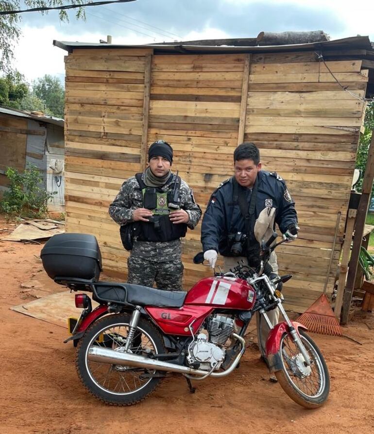 Agentes policiales junto a la motocicleta hurtada que fue recuperada.