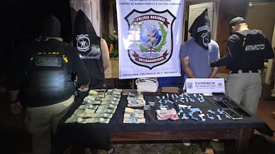 Adolfo Ezequiel Espínola González y Mathias José González junto con las evidencias encontradas en poder de ambos durante un allanamiento en Guarambaré, bajo el resguardo de los agentes antidrogas de la Policía.
