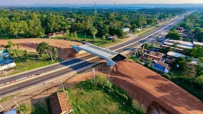 Vista aérea de un viaducto en construcción sobre una carretera rural, sin personas visibles alrededor.