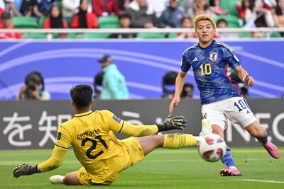 Japan's midfielder #10 Ritsu Doan looks on as Indonesia's goalkeeper #21 Ernando Ari slides past the ball during the Qatar 2023 AFC Asian Cup Group D football match between Japan and Indonesia at al-Thumama Stadium in Doha on January 24, 2024. (Photo by HECTOR RETAMAL / AFP)