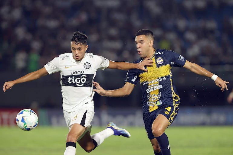 Diego Melgarejo (d) de Sportivo Trinidense disputa el balón con Alex Franco de Olimpia este miércoles, durante un partido de la Copa Sudamericana entre Sportivo Trinidense y Olimpia en el estadio Defensores del Chaco en Asunción (Paraguay).