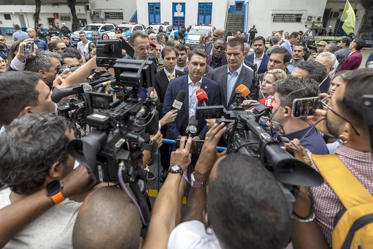 El senador y candidato a la presidencia de Brasil por el Partido Liberal, Flávio Bolsonaro (c), habla con la prensa durante una visita el Batallón de la Policía Militar, en Río de Janeiro (Brasil).  
