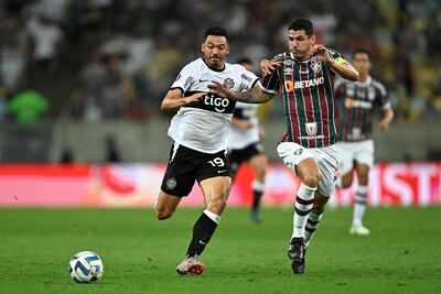 El paraguayo Walter González (i), futbolista de Olimpia, pelea por el balón en el partido contra Fluminense por los cuartos de final de la Copa Libertadores 2023 en el estadio Maracaná, en Río de Janeiro, Brasil.