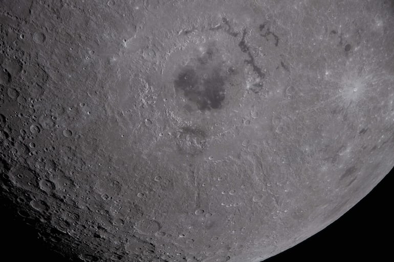 Fotografía cedida por la NASA de una imagen capturada por la tripulación de la misión Artemis II este lunes, de la mitad inferior de la Luna donde se observa la cuenca Orientale en la parte superior central de la imagen. 