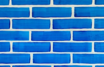 Muestra de ladrillos pintados en tonos azules, dispuestos uniformemente, en un ambiente sin personajes presentes.