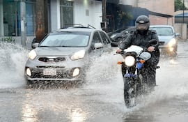 Imagen ilustrativa: raudales generados por las lluvias y personas movilizándose en vehículos.