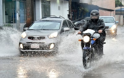 Imagen ilustrativa: raudales generados por las lluvias y personas movilizándose en vehículos.