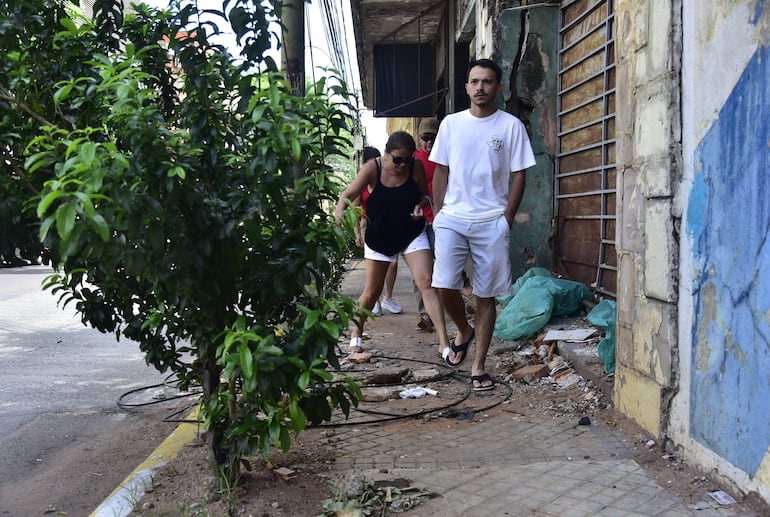 Una familia sortea una vereda destrozada de la calle Presidente Franco.