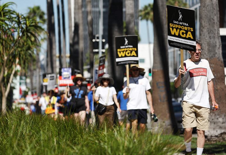 Un letrero dice 'SAG-AFTRA apoya a WGA' mientras los miembros de SAG-AFTRA caminan en la línea de piquete en solidaridad con los trabajadores en huelga de WGA (Writers Guild of America) frente a las oficinas de Netflix el 13 de julio de 2023 en Los Ángeles , California.