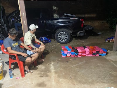 Los dos detenidos y las evidencias incautadas durante el allanamiento.