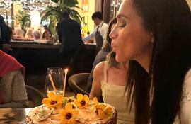 Meghan Markle a punto de apagar las velitas de su torta el día de su cumpleaños número 44.