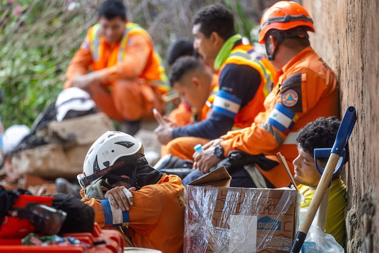 Rescatistas de El Salvador descansan en medio de las labores de búsqueda de sobrevivientes a los terremotos, en Catia La mar, La Guaira (Venezuela).