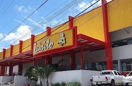 Fachada de la tienda Liragüito en colores amarillo y rojo, con vehículos estacionados y cielo despejado.