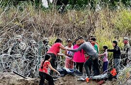 Un grupo de migrantes cruzan el río Bravo para ingresar a la frontera con Estados Unidos, desde la ciudad de Matamoros (México).