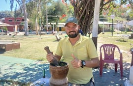 Hombre sonriente con camiseta amarilla y gorra verde