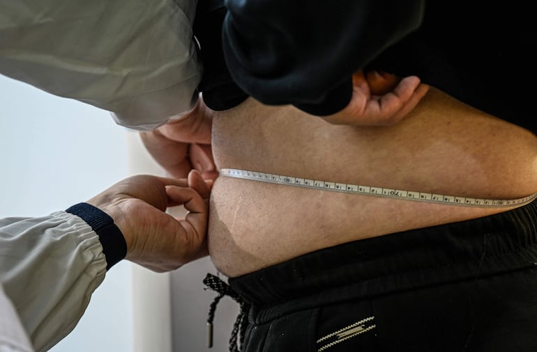 La fotografía tomada el 23 de marzo de 2026 muestra a un participante masculino mientras le miden la cintura en un centro comunitario local en Wuxi, en la provincia de Jiangsu, en el este de China.