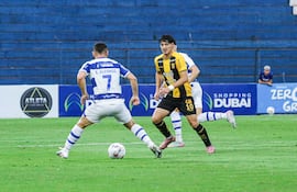 Maniobra del "avícola" Elías Alfonso ante el intento de presión de Derlis Rodríguez, en una acción registrada en el primer tiempo del partido celebrado en la tarde de este domingo capital del Amambay.